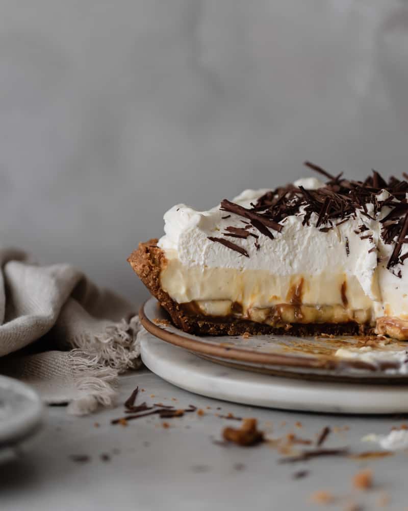 Banoffee Banana Cream Pie with Dulce de Leche Caramel, Chocolate Curls, and Whipped Cream sitting on plate