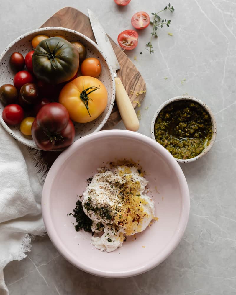 Heirloom tomatoes, lemon thyme ricotta and pistachio pesto ready to be used to make the galette