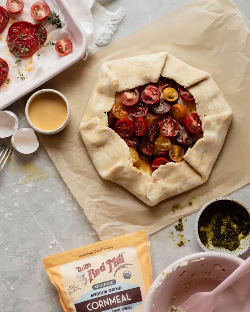 Assembled heirloom tomato ricotta galette with pistachio pesto ready to be egg washed and baked