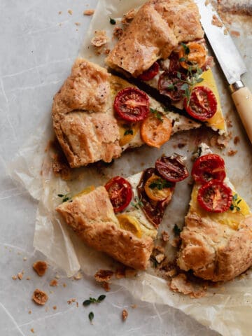 Slices of heirloom tomato galette with ricotta and pistachio pesto